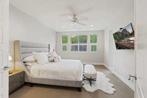 Carpeted bedroom featuring ceiling fan