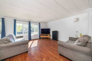 Living room with a textured ceiling and hardwood / wood-style floors