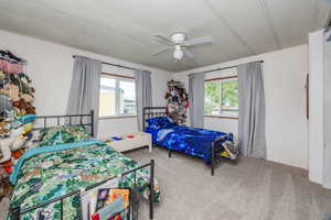 Carpeted bedroom with a textured ceiling and ceiling fan