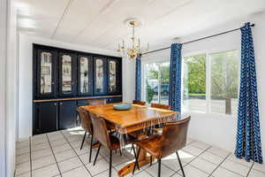 Dining area featuring a chandelier and light tile patterned flooring