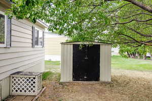 View of outdoor structure featuring a lawn