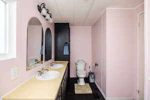 Bathroom with vanity, toilet, a textured ceiling, and a healthy amount of sunlight