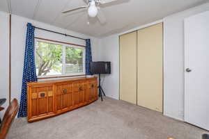 Interior space featuring a textured ceiling, ceiling fan, and light carpet