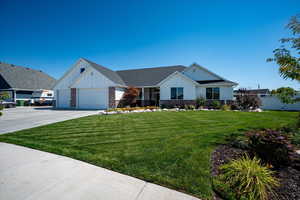 View of front facade featuring a front lawn and a garage