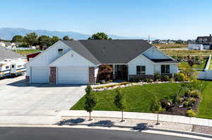 Exterior front of home with mountain view, fully landscaped yard. and RV pad.