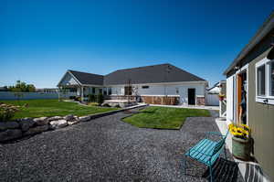 Rear view of property featuring xeriscape next to work shop.