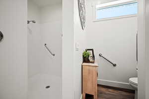 Owner's suite walk-in shower with grab bars and separate water closet.