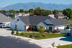 View of front of house featuring a mountain view, 3 car garage, and full landscaping.