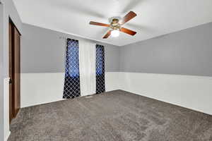 Spare room with a textured ceiling, carpet, and ceiling fan