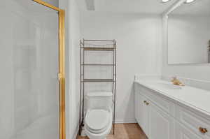 Bathroom featuring vanity, toilet, tile patterned floors, and walk in shower