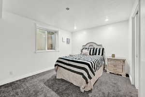 Bedroom with a textured ceiling and carpet floors