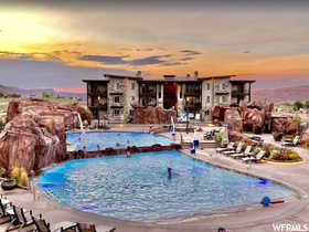 Community Pool at dusk with pool water feature and a patio