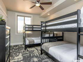 Carpeted bedroom featuring ceiling fan