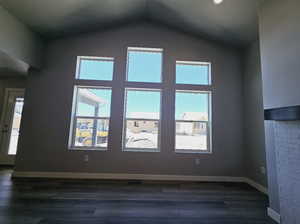 Interior space featuring dark wood-type flooring and lofted ceiling