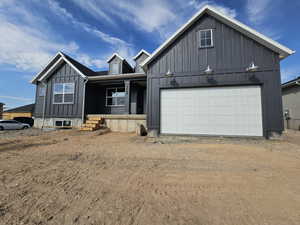 View of front of home with a garage and a porch