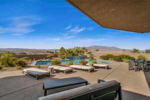 View of patio / terrace featuring a fenced in pool, a mountain view, outdoor lounge area, and pool water feature