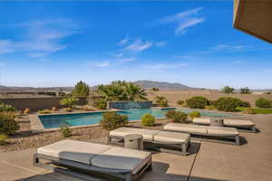 View of swimming pool with pool water feature, a mountain view, and a patio