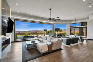 Living room with plenty of natural light, ceiling fan, hardwood / wood-style flooring, and a fireplace