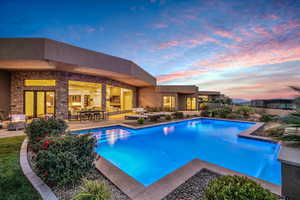 Pool at dusk with a patio area and pool water feature