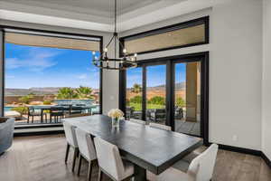 Dining space with a mountain view, hardwood / wood-style floors, and an inviting chandelier