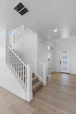 Entryway with a textured ceiling and light hardwood / wood-style flooring