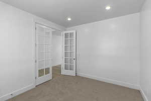 Unfurnished room with carpet floors and french doors