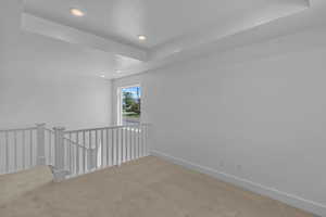 Empty room with a tray ceiling and carpet