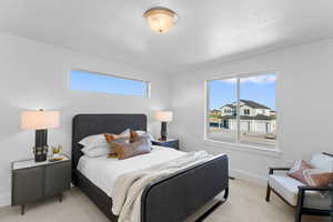 Bedroom with light carpet and multiple windows