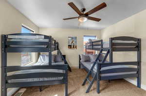 Carpeted bedroom featuring ceiling fan