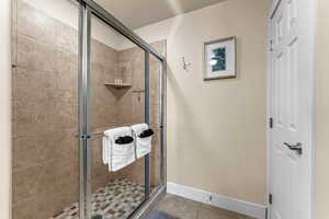 Bathroom with a shower with shower door and tile patterned flooring