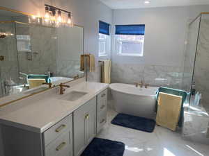 Bathroom featuring vanity, tile walls, and plus walk in shower