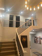 Stairs featuring wood-type flooring and a towering ceiling