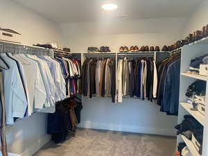 Walk in closet with carpet flooring and vaulted ceiling