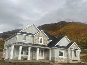 View of front facade featuring central AC, a mountain view, and a porch