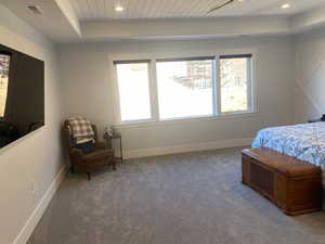 Bedroom featuring dark colored carpet and wood ceiling