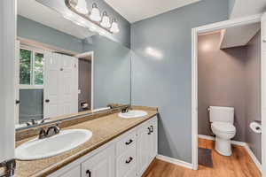 Bathroom featuring hardwood / wood-style floors, toilet, and vanity