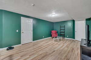 Sitting room with a textured ceiling and light hardwood / wood-style flooring