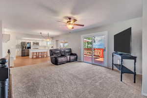 Carpeted living room featuring ceiling fan