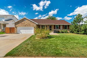 Single story home with a garage and a front yard