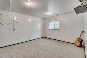 Bedroom with a textured ceiling and light carpet