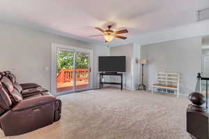 Carpeted living room featuring ceiling fan