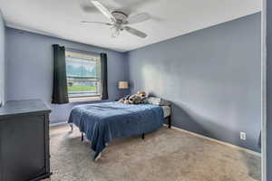 Bedroom with light colored carpet and ceiling fan