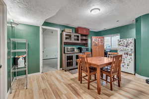 Dining room featuring a textured ceiling and light hardwood / wood-style flooring