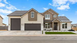 View of front of home with metal roof, concrete driveway, a standing seam roof, and fence