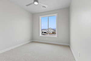 Unfurnished room featuring baseboards, visible vents, ceiling fan, and light colored carpet