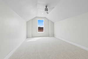 Bonus room featuring lofted ceiling, carpet flooring, ceiling fan, and baseboards