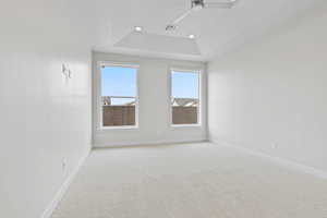 Unfurnished room featuring a tray ceiling, recessed lighting, visible vents, light carpet, and baseboards