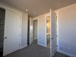 Unfurnished bedroom with a closet and dark carpet