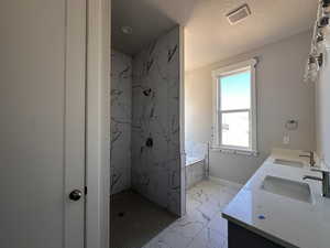 Bathroom featuring vanity and shower with separate bathtub