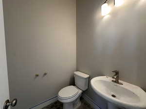 Bathroom featuring toilet, tile patterned flooring, and sink